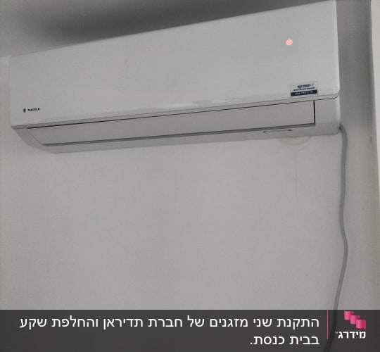 מזגן קיר לבן עם נורית חיווי אדומה